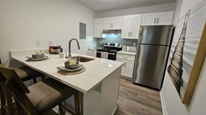 Tampa apartment for rent - A modern kitchen with a dining table and chairs.