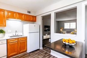 Athens apartment for rent - A kitchen with a white refrigerator and wooden cabinets.