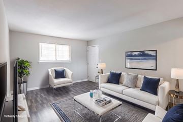 Athens apartment for rent - A living room with a white couch, a white chair, a coffee table, and a painting on the wall.