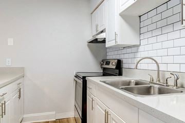Jacksonville apartment for rent - A kitchen with a black oven and white cabinets.