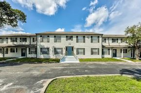 Jacksonville apartment for rent - A building with a green lawn in front and a tree to the left.