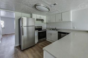Jacksonville apartment for rent - A kitchen with a stainless steel refrigerator and white countertops.