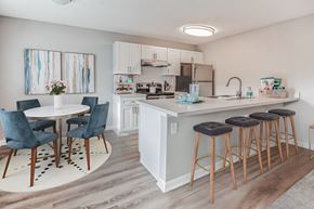 St Petersburg apartment for rent - A kitchen with a white counter and blue chairs.