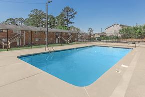 Athens apartment for rent - A large blue swimming pool in a sunny outdoor setting.