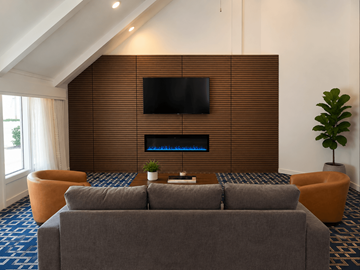 Colorado Springs apartment for rent - A modern living room with a grey couch and a flat screen TV mounted on a wooden wall.