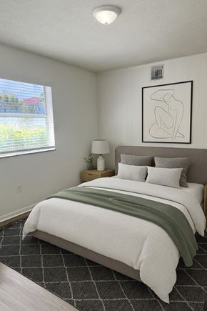 Boca Raton apartment for rent - A bedroom with a large bed and a framed picture on the wall.