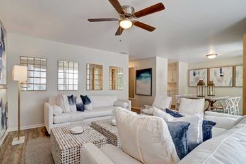 Fort Walton Beach apartment for rent - A living room with a white couch and a ceiling fan.