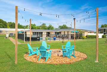 Tallahassee apartment for rent - A set of blue chairs are arranged around a fire pit.