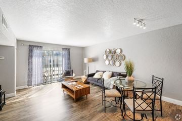 Tallahassee apartment for rent - A living room with a glass table and chairs, a sofa, and a coffee table.