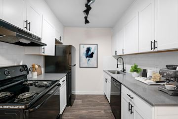 Decatur apartment for rent - A kitchen with black stove top oven and white cabinets.