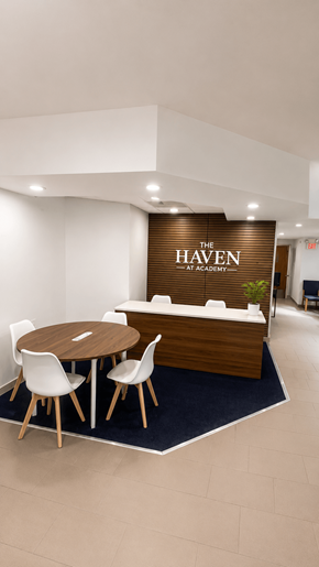 Colorado Springs apartment for rent - A conference room with a brown table and chairs with a sign that says "The Haven at Apartments".