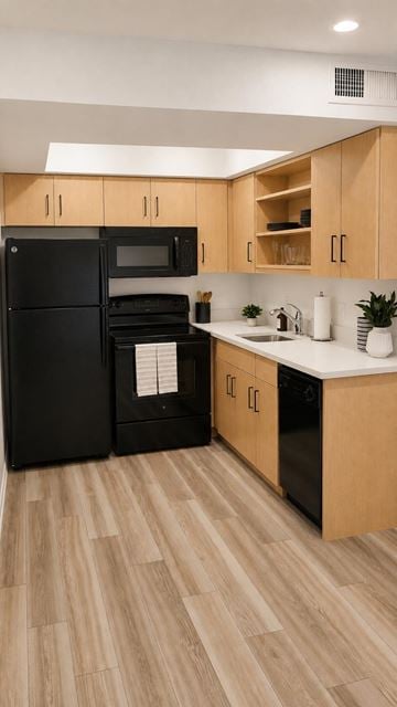 Somerset apartment for rent - A black refrigerator and microwave in a kitchen with wooden cabinets.