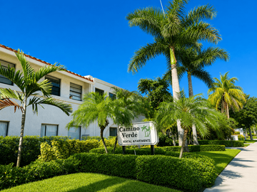 Boca Raton apartment for rent - A sign for Camino Verde Senior Apartments is in front of a building with a palm tree.