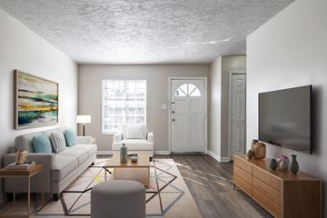 Macon apartment for rent - A living room with a white couch, a coffee table, and a painting on the wall.