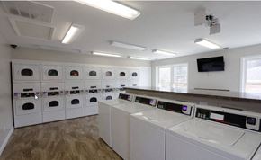 Evansville apartment for rent - a laundry room with washers and dryers and a row of washing machines