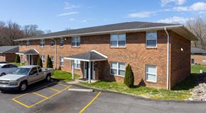 Evansville apartment for rent - a brick building with a car parked in a parking lot