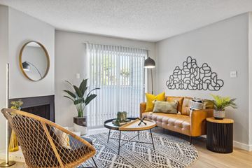 Carrollton apartment for rent - A living room with a yellow chair and a black and white rug.