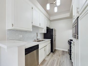 Encino apartment for rent - A kitchen with white cabinets and a black refrigerator.