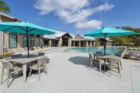 Spring apartment for rent - a patio with tables and umbrellas next to a swimming pool