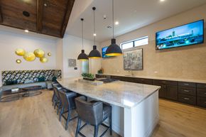 Spring apartment for rent - a kitchen with a large island and a dining area with chairs