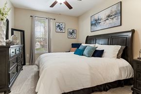 Katy apartment for rent - A bedroom with a large bed and a ceiling fan.