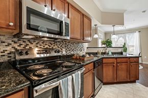 Katy apartment for rent - A kitchen with a black stove top oven and a black microwave above it.