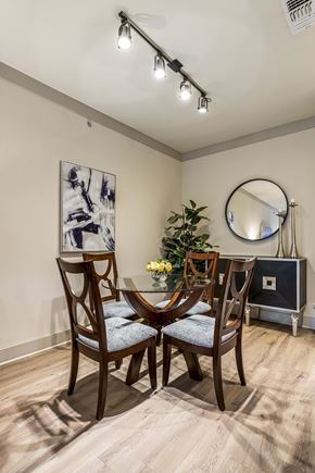 San Antonio apartment for rent - A dining room with a round mirror and a vase of flowers on the table.