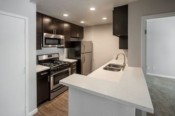 Hollywood apartment for rent - a kitchen with stainless steel appliances and a white counter top