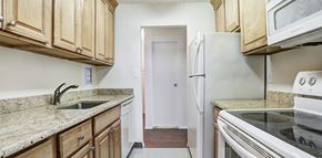 Hackensack apartment for rent - a kitchen with wooden cabinets and white appliances at The Ivanhoe Apartments, Hackensack, NJ, 07601