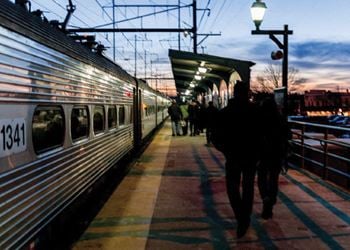 A man walking on a train platform next to a train
