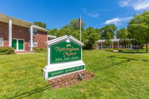 Montvale apartment for rent - a green and white sign that says northampton manor in front of a brick building at Nottingham Manor Apartments, Montvale, NJ, 07645