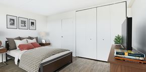 Hackensack apartment for rent - a bedroom with white walls and a bed with a red pillow at The Ivanhoe Apartments, Hackensack, 07601