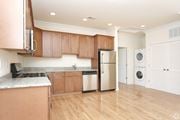 Metuchen apartment for rent - a kitchen with brown cabinets and a white washer and dryer at Greenway Village Apartments, Metuchen, NJ