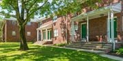 Montvale apartment for rent - a brick building with green doors and a tree in front of it at Nottingham Manor Apartments, New Jersey