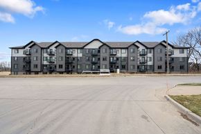 Coralville apartment for rent - A large, modern apartment complex with a parking lot in front.