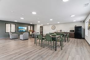 Hiawatha apartment for rent - A modern dining room with a wooden floor and a large table surrounded by chairs.