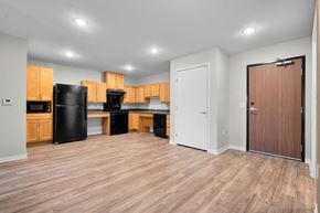 Coralville apartment for rent - A kitchen with wooden cabinets and a black fridge.