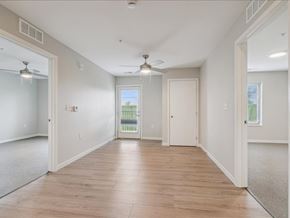 Iowa City apartment for rent - A spacious room with wooden flooring and white walls.