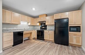 Dubuque apartment for rent - A kitchen with wooden cabinets and black appliances.