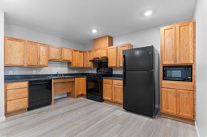 Cedar Rapids apartment for rent - a kitchen with black appliances and wooden cabinets