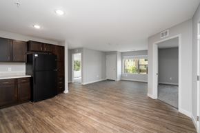 Plymouth apartment for rent - an empty kitchen and living room with a black refrigerator