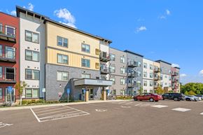 Shakopee apartment for rent - a parking lot with cars in front of an apartment building