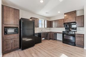 Hiawatha apartment for rent - A kitchen with wooden cabinets and black appliances.