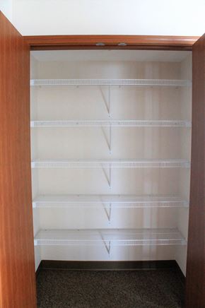 St Paul apartment for rent - A pantry with a brown door and white shelves.