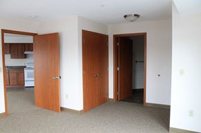 St Paul apartment for rent - A room with a carpeted floor and two wooden doors.