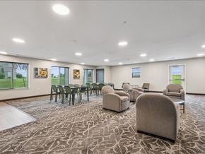 Iowa City apartment for rent - A spacious room with a carpeted floor and a variety of seating options.