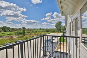 Kasson apartment for rent - A balcony with a view of a field and trees.