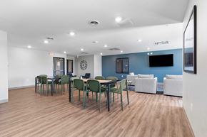 Cedar Rapids apartment for rent - a dining room with tables and chairs and a tv on the wall