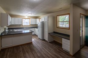 Albany townhouse for rent - A kitchen with white cabinets and a black counter top.