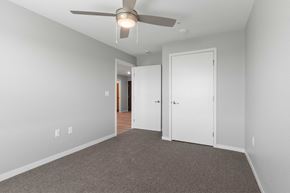 Cedar Rapids apartment for rent - a bedroom with a ceiling fan and a door to a hallway